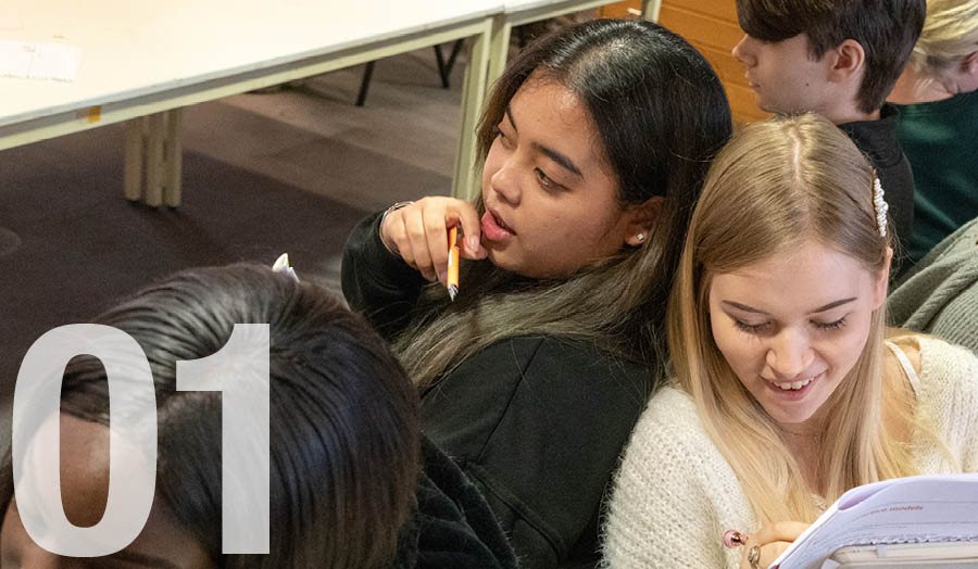 Two London Met female students sitting back to back