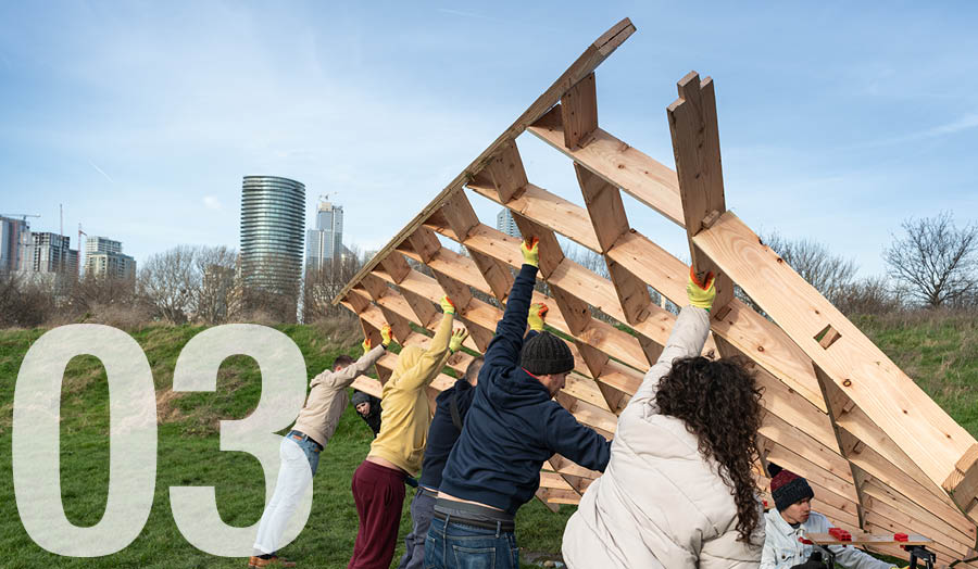 Architecture students working together to raise a structure