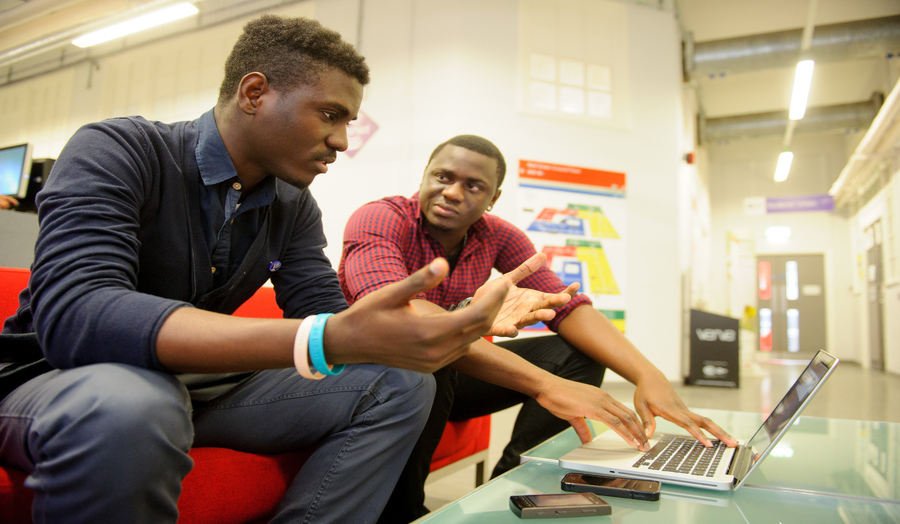 Two male students sitting on a couch