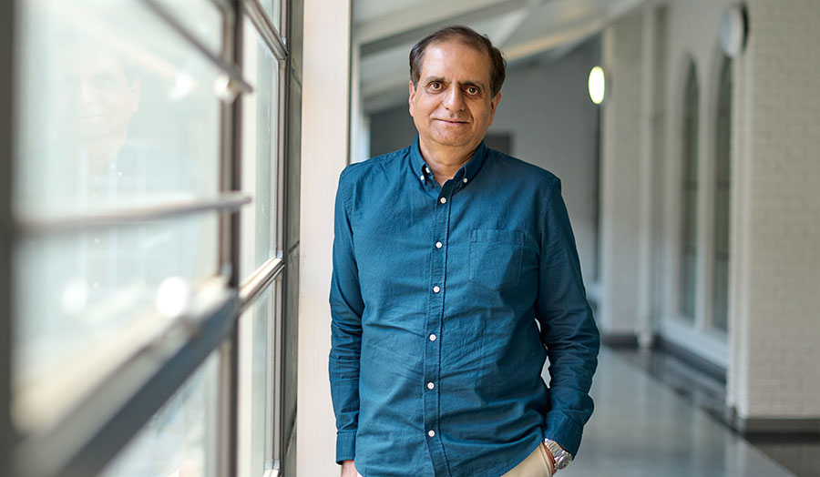 naveed wearing a blue shirt standing next to a window