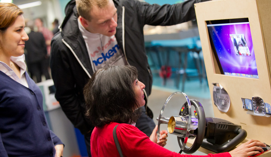 School of Computing Show - three people testing a computer game made by a student