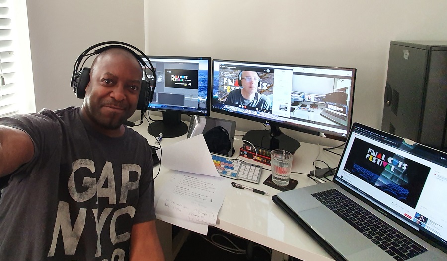 a man faces the camera with computers behind him