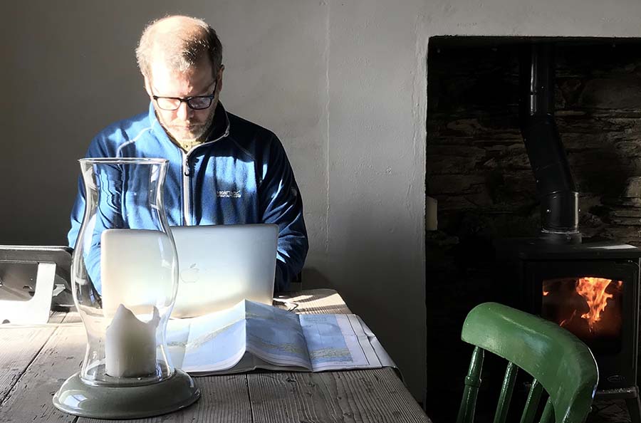 Mike Baldwin sat at a table working next to a wood burning stove