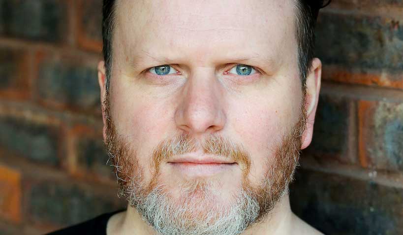 Christopher Holt against a brick wall