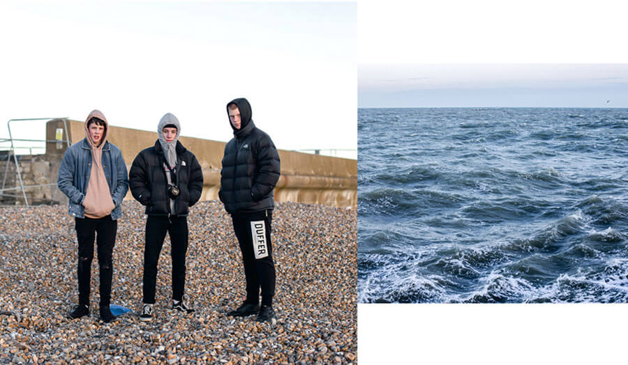 Three boys standing on a beach