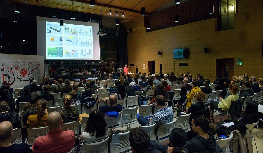 A seated audience listening to a lecture in a fairly large seminar room