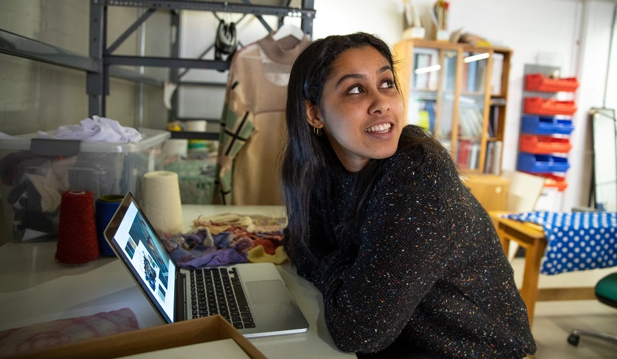 student at desk with laptop in a studio