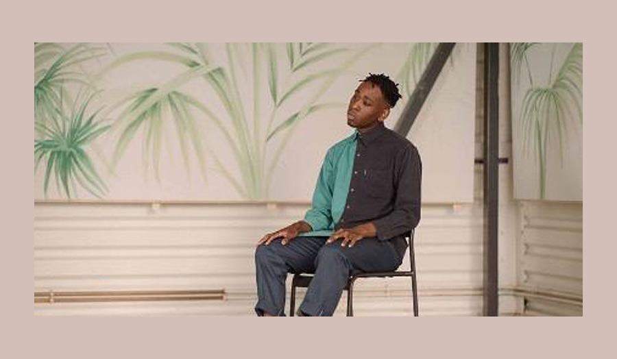 Salem's portrait, sitting on a chair and wearing a green and black T-shirt