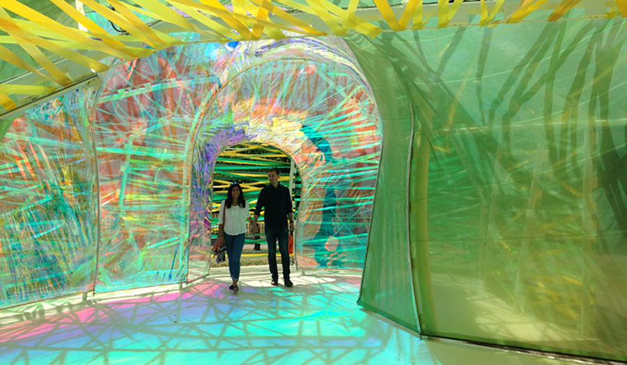 A couple holding hands and going through an colourful corridor