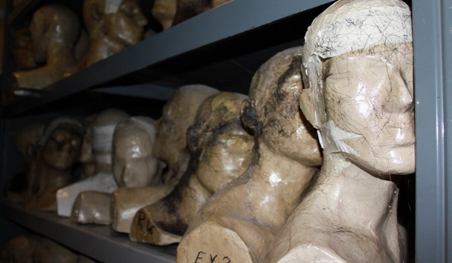 many plaster cast heads on shelves