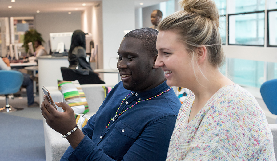 Two students chatting whilst sitting down at Holloway Road campus