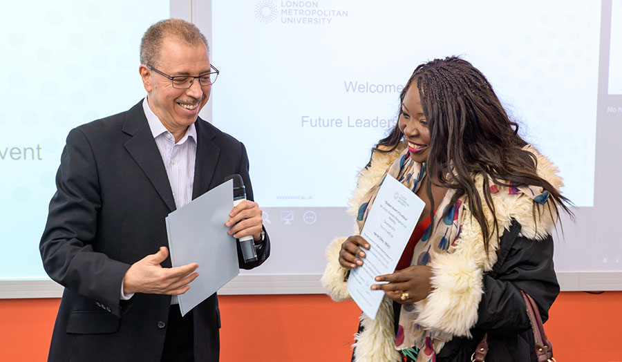 Student smiling receiving certificate from lecturer