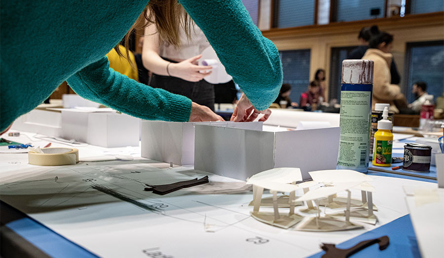 Girl leaning over adding bits to an architecture model