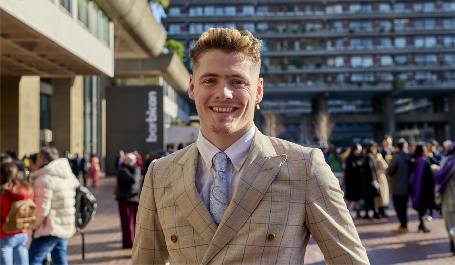 A male student wearing a tan suit