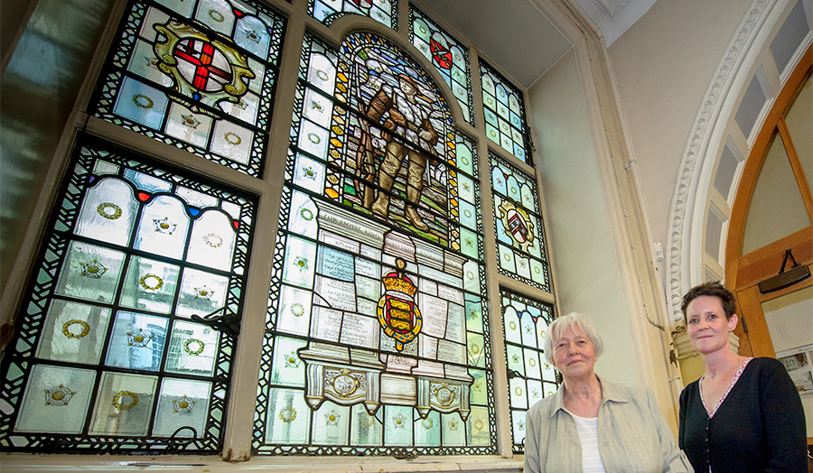 Photo of stained glass memorial window in Jewry street lobby with two ladies 