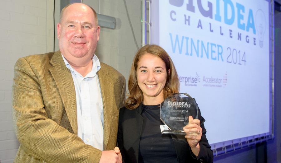 Paul Bowler shakes hand of Georgia Bacco, who is holding her award. Both smile at the camera 