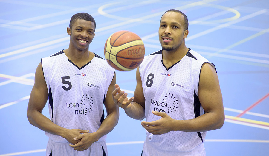 Two student basketball players in the sports hall in kit