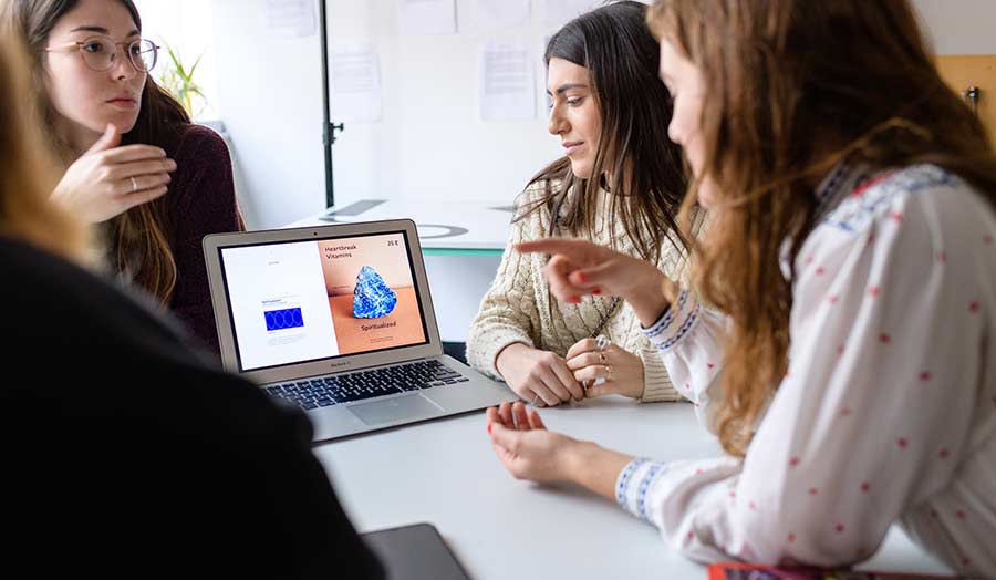 Women sitting around the table with a laptop