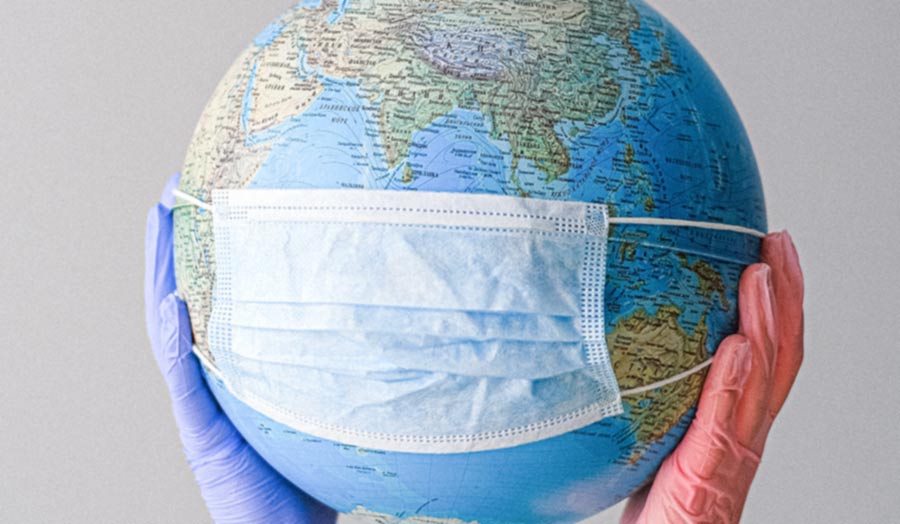 Earth globe with mask and raised in the air with two hands