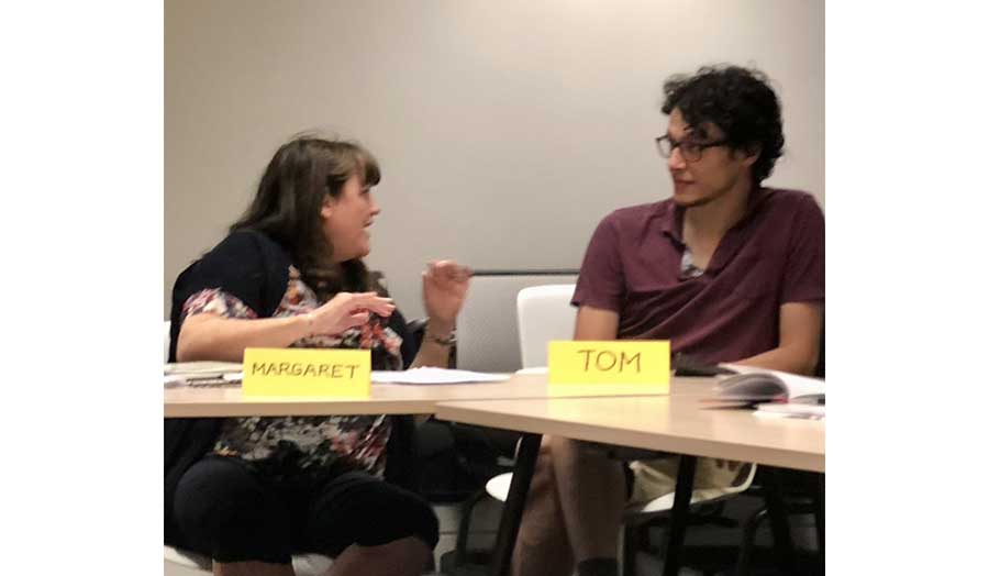 Female and male students talking to one another