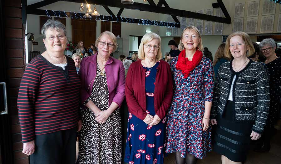 A group of women standing in front of the camera smiling