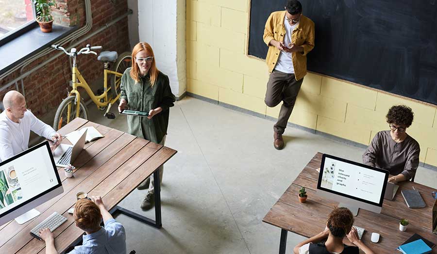 people sitting at the desks and discussing in the office setting