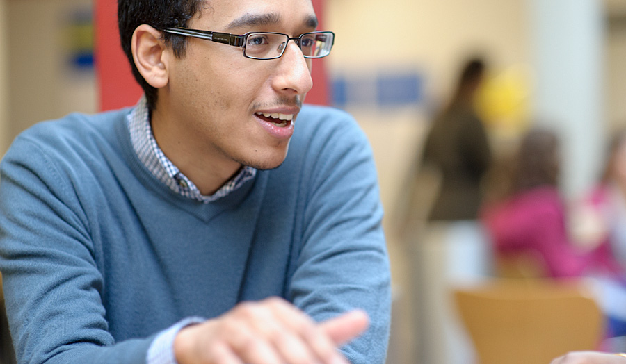 Male student talking to fellow group members 