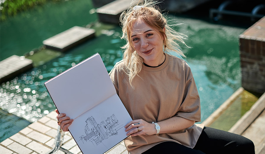 Hailey with her sketchbook in a corner of the Barbican