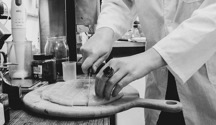 Chopping leather-like material on a board